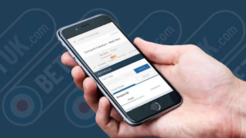 Reviewer holding betuk app displaying football bet builder function