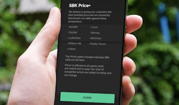 Bettingapps com reviewer holding i Phone displaying info about SBK Price feature