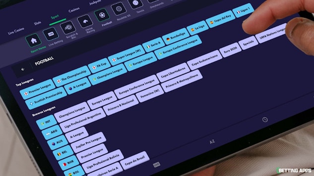 Someone browsing football leagues on the Grosvenor Sport app with an i Pad